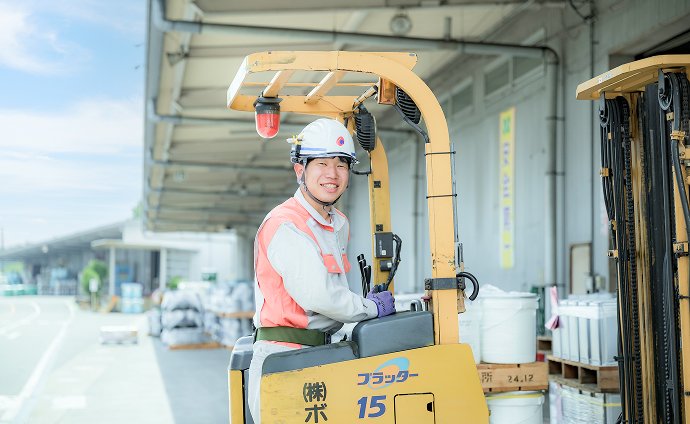 青空の下でトラクターを運転する社員